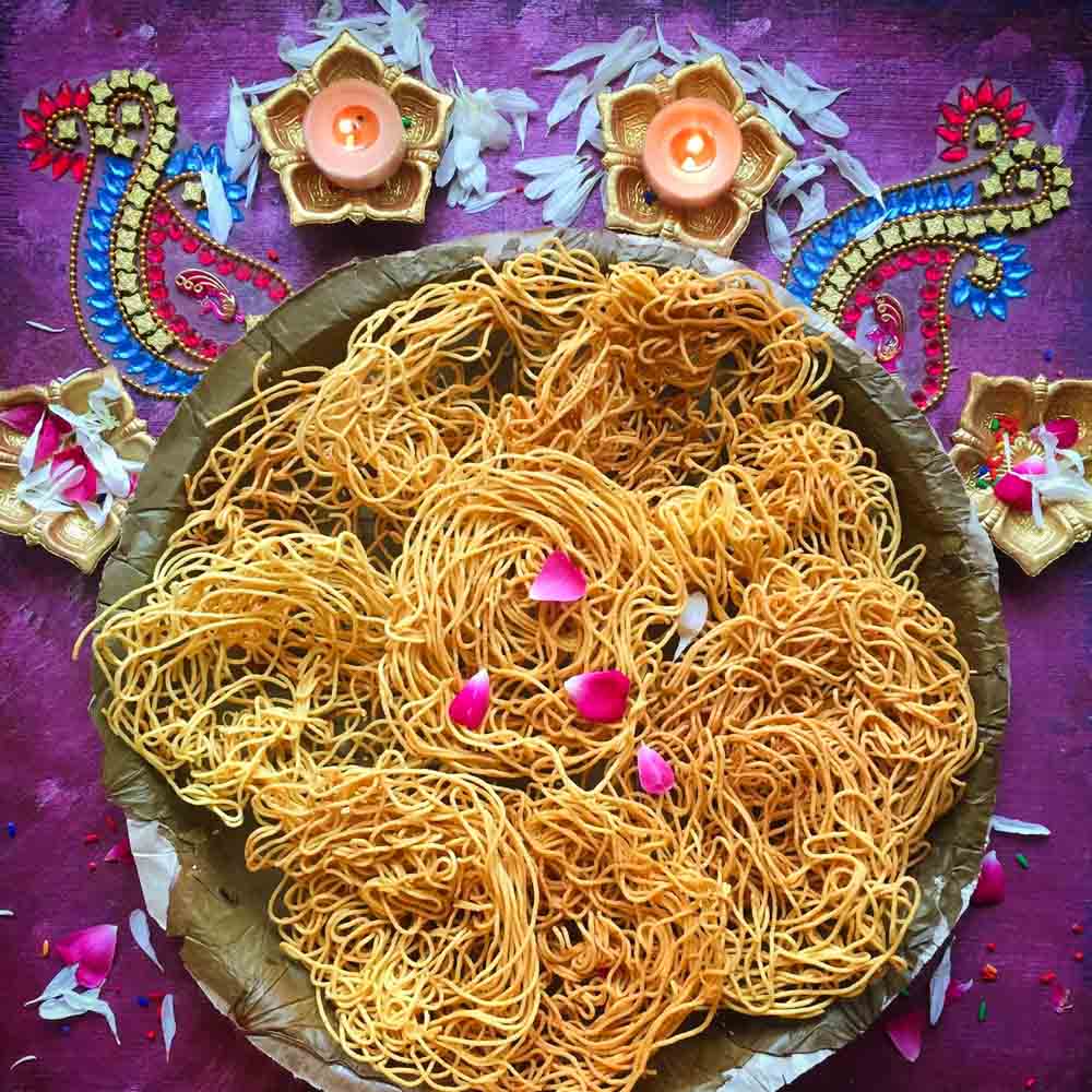 A plate with Omapodi and around it are placed diyas